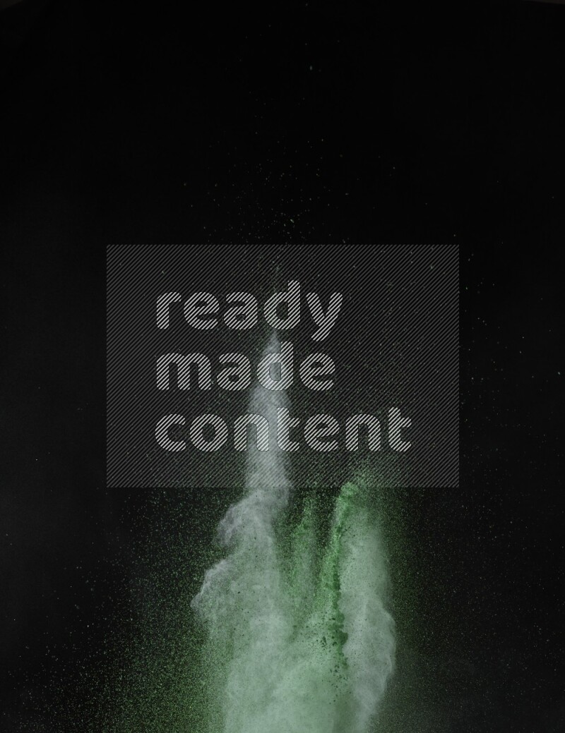 A side view of green powder explosion on black background