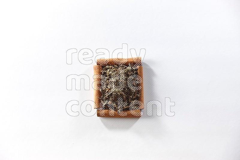 A single square of cinnamon sticks full of dried basil on white flooring