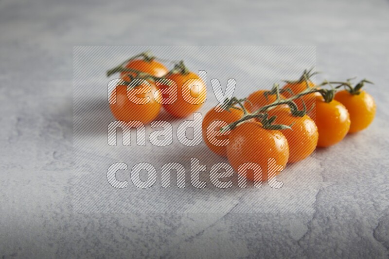 Orange cherry tomato vein on a light grey textured background 45 degree