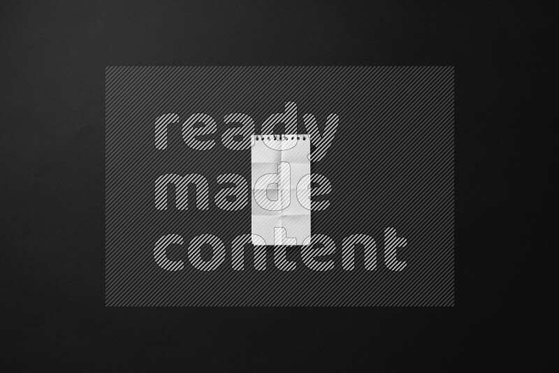 Folded notebook sheet on black background