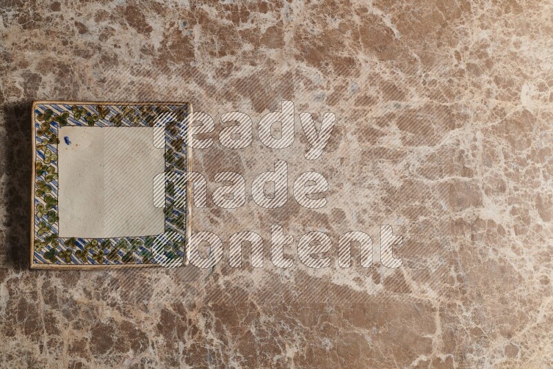 A decorative pottery plate on beige marble background