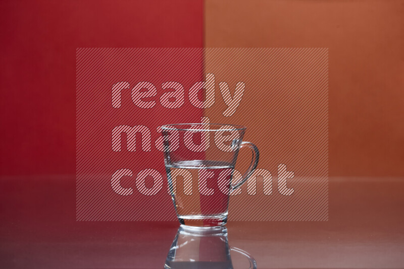 The image features a clear glassware filled with water, set against red and dark orange background