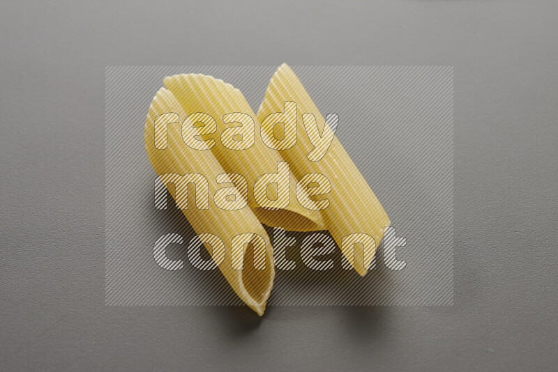 Penne pasta on grey background