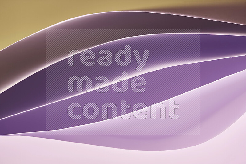 This image showcases an abstract paper art composition with paper curves in purple and gold gradients created by colored light