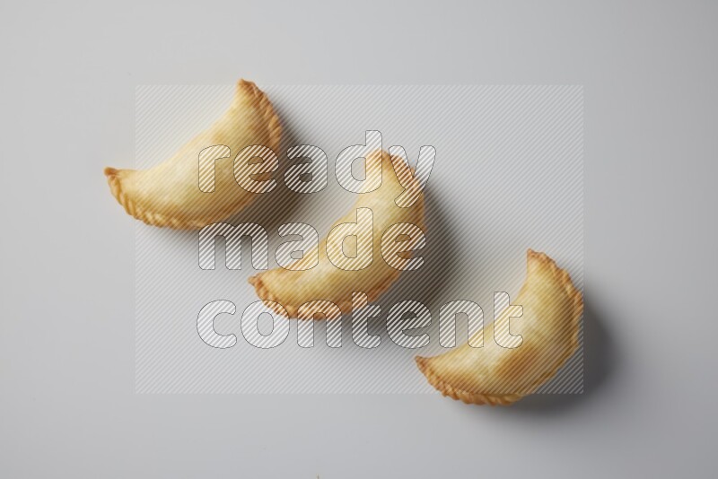 Three fried sambosa from a top angle on a white background