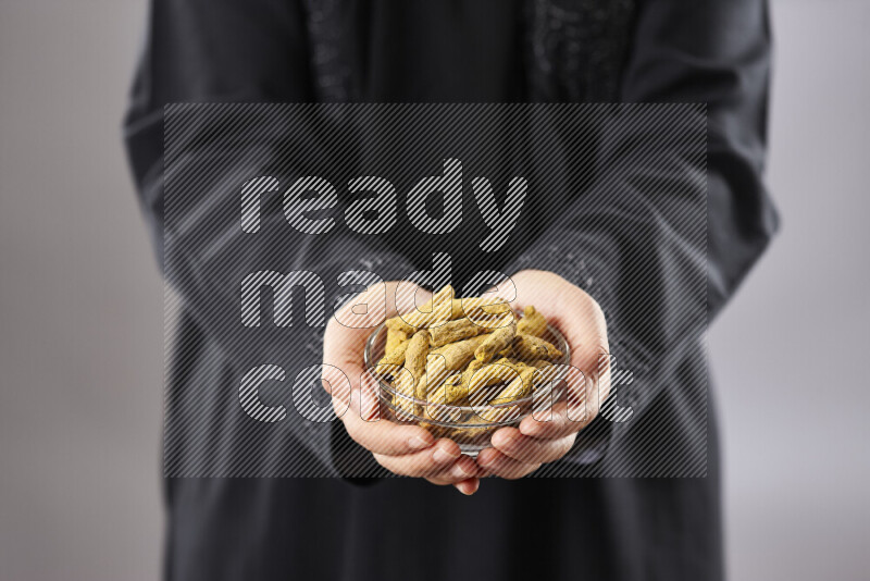 Woman in abaya holding different kinds of spices in different positions