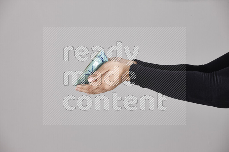A woman in black abaya holding different pottery essentials in different positions