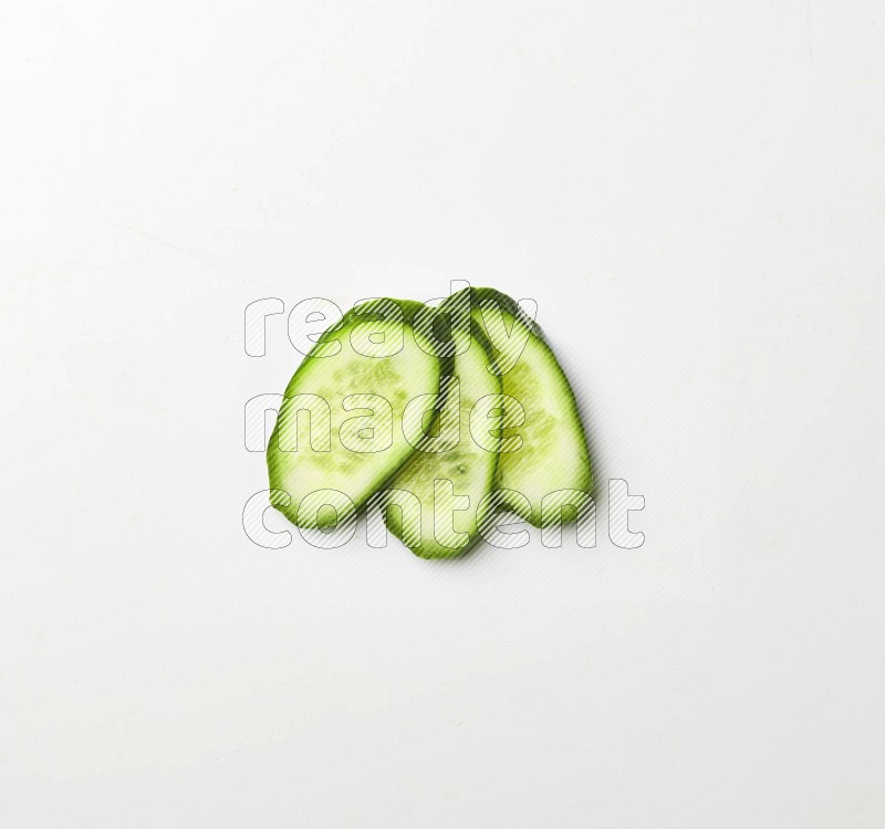 three cucumber slices on white background