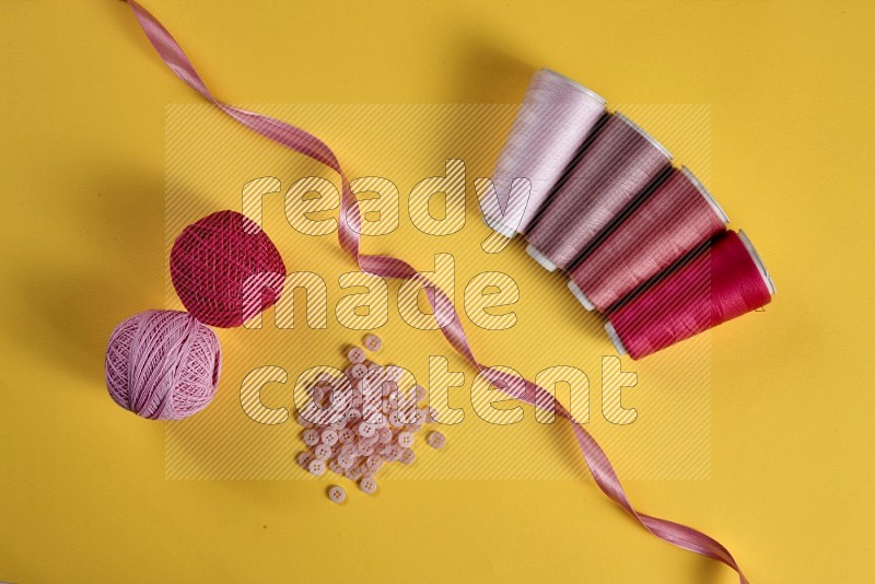 Pink sewing supplies on yellow background