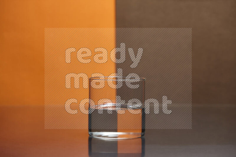The image features a clear glassware filled with water, set against orange and brown background