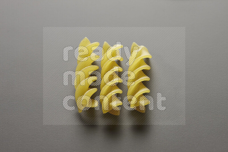 Fusilli pasta on grey background