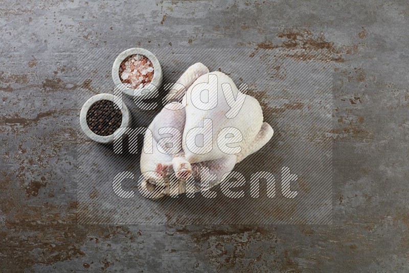 whole raw chicken  direct on a rustic grey background