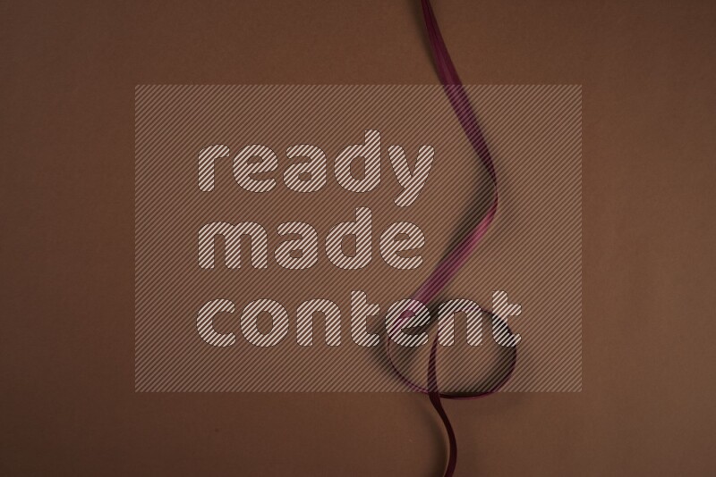 مجموعة من أدوات الخياطة والتفصيل حمراء اللون على خلفية بنية