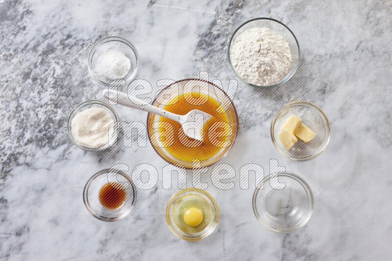Cookies step by step with its ingredient, flour, butter, brown sugar, egg, vanilla extract, white sugar, chocolate chips and baking soda on grey marble background