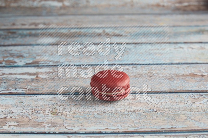 45º Shot of Red Velvet macaron on light blue wooden background