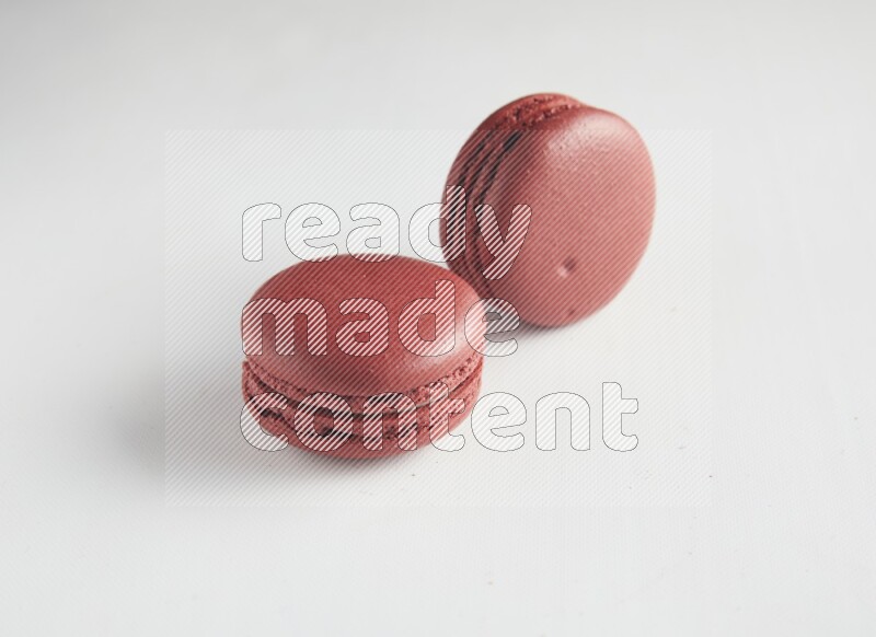 45º Shot of two Red Velvet macarons on white background
