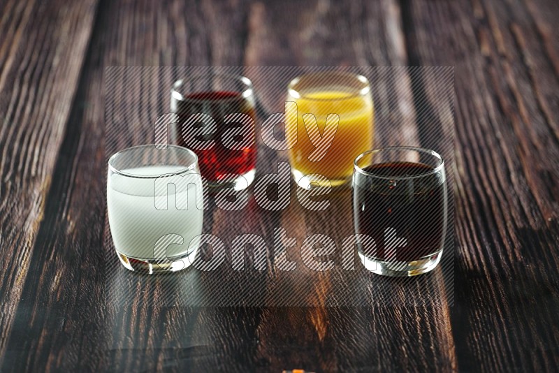 Cold drinks in a glass cup such as water, tamarind, qamar eldin, sobia, milk and hibiscus on wooden background