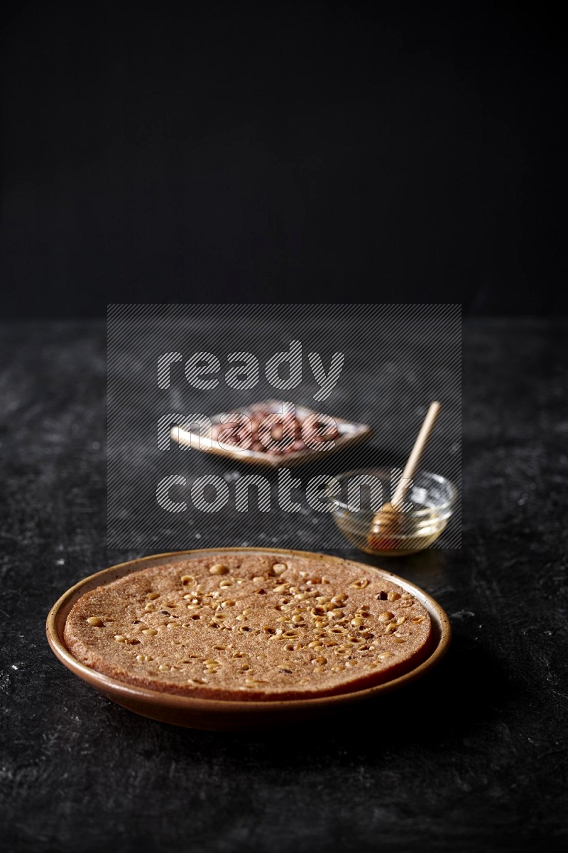 Basbousa with nuts and honey in a dark setup