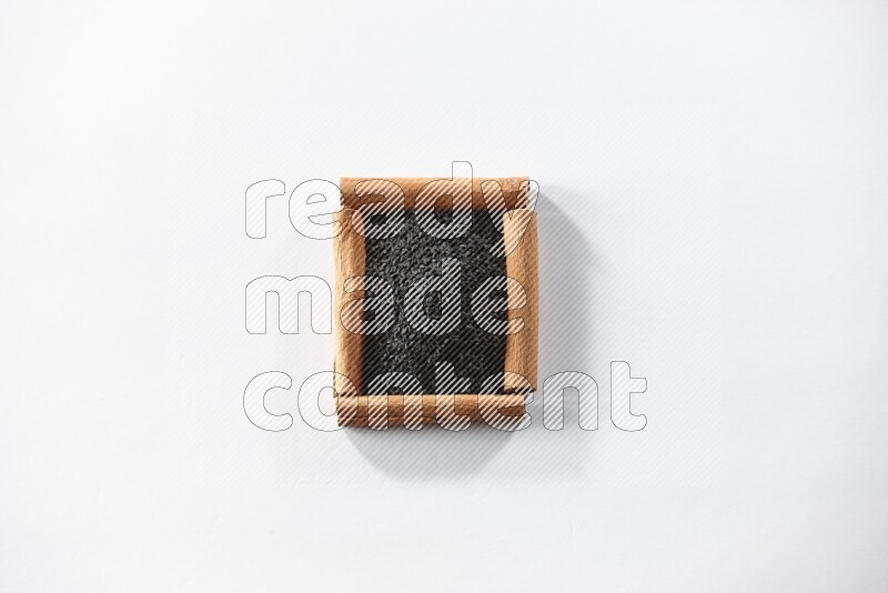 A single square of cinnamon sticks full of black seeds on white flooring