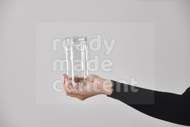 A woman in black abaya holding different glassware in different positions