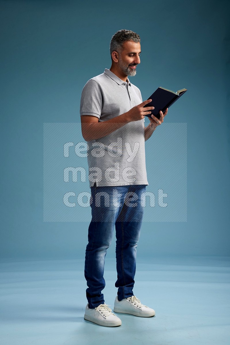 Man Standing reading book on blue background