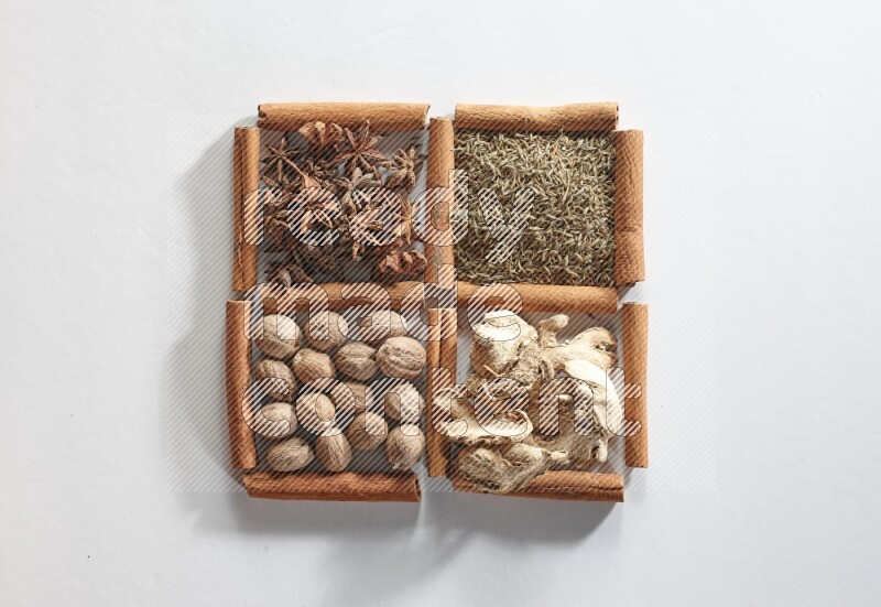 4 squares of cinnamon sticks full of star anise, ginger, cumin and nutmeg on white flooring