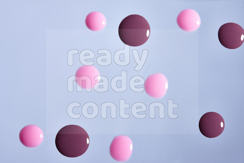 لقطات مقربة لقطرات من اللون الأرجواني والوردي على الخلفية