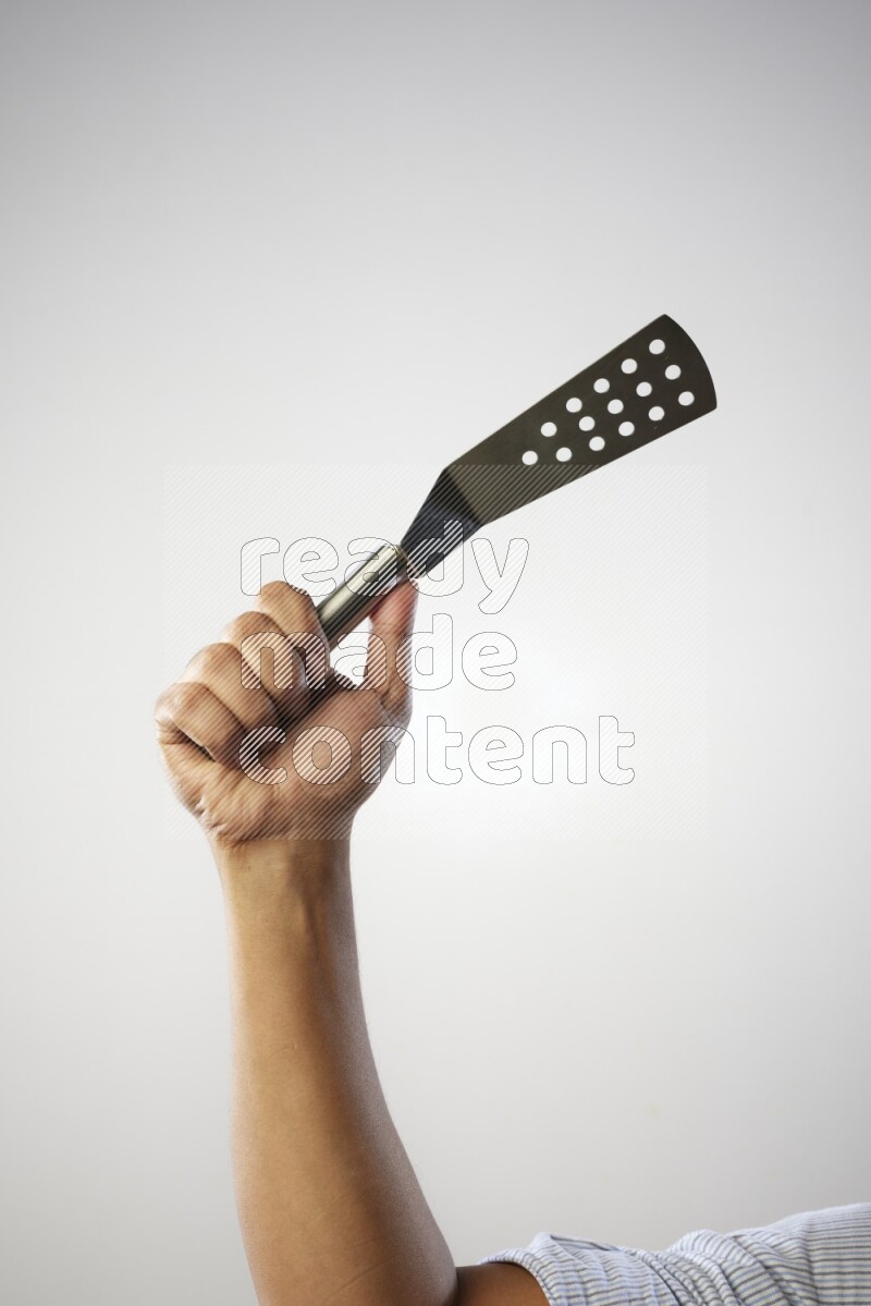 Male Hand Holding Burger Flipper on white background