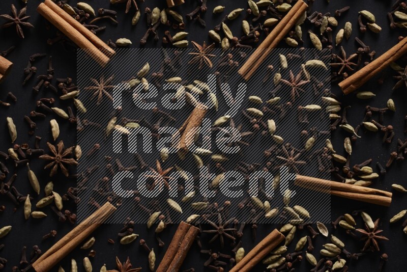 Cinnamon Sticks, Star anise, Cardamom and cloves on a black background