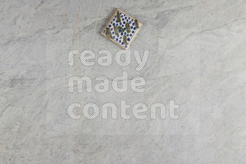 A decorative pottery coaster on grey marble background