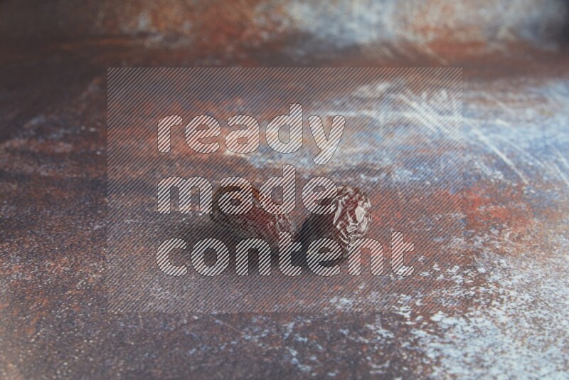 two madjoul dates on a rustic reddish background