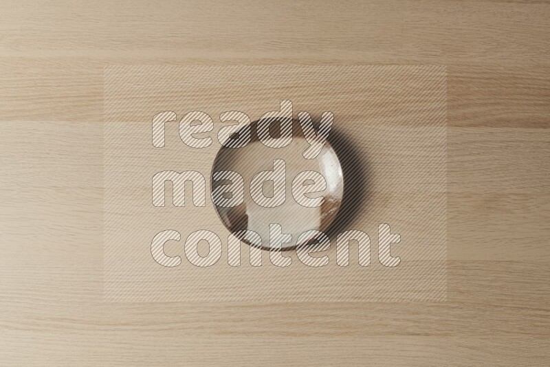 A multicolored pottery plate on light wooden background