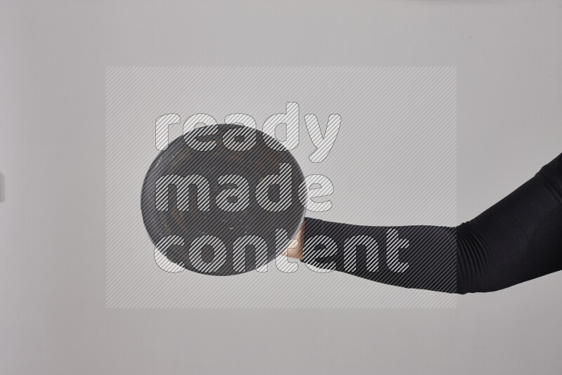 امرأة ترتدي عباءة سوداء تحمل أدوات فخارية مختلفة في أوضاع متعددة