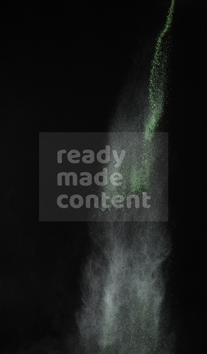 A side view of green powder explosion on black background