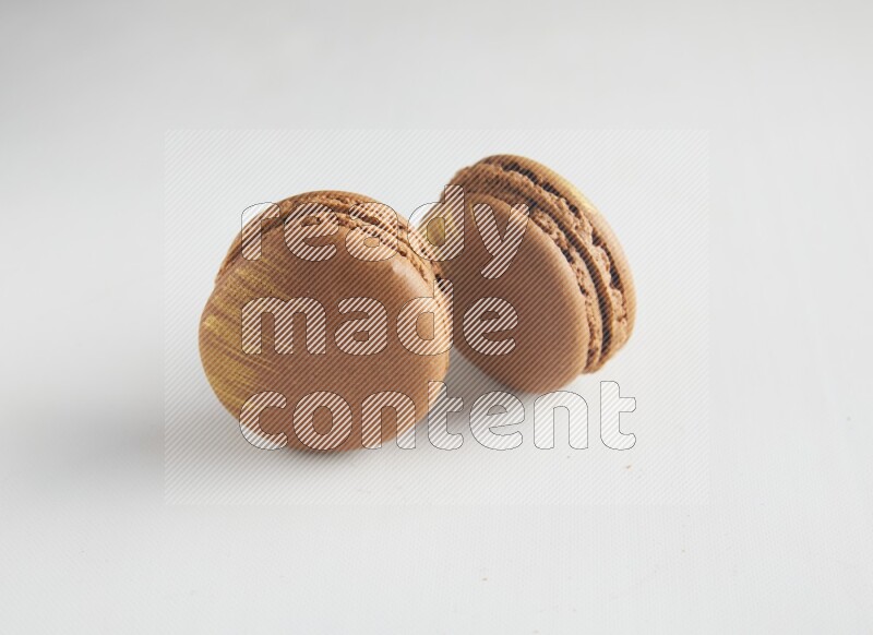 45º Shot of two Brown Coffee macarons on white background