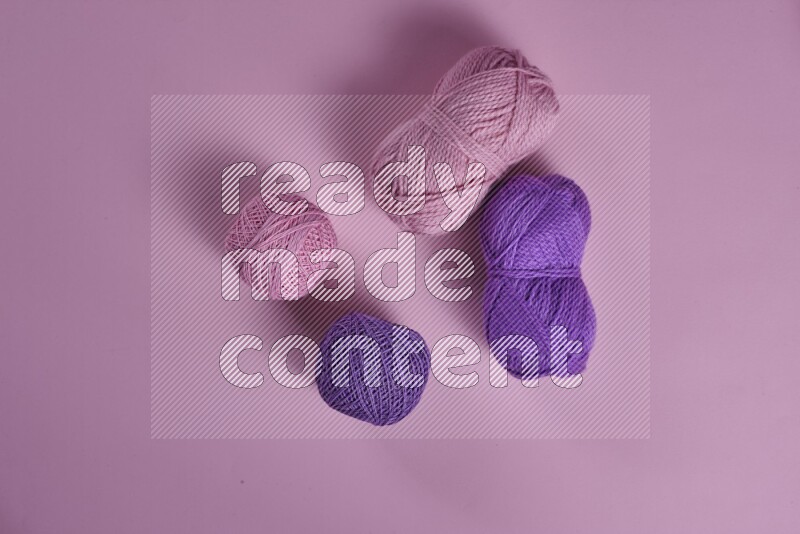 A purple and pink collection of sewing and tailoring tools arranged on a pink background