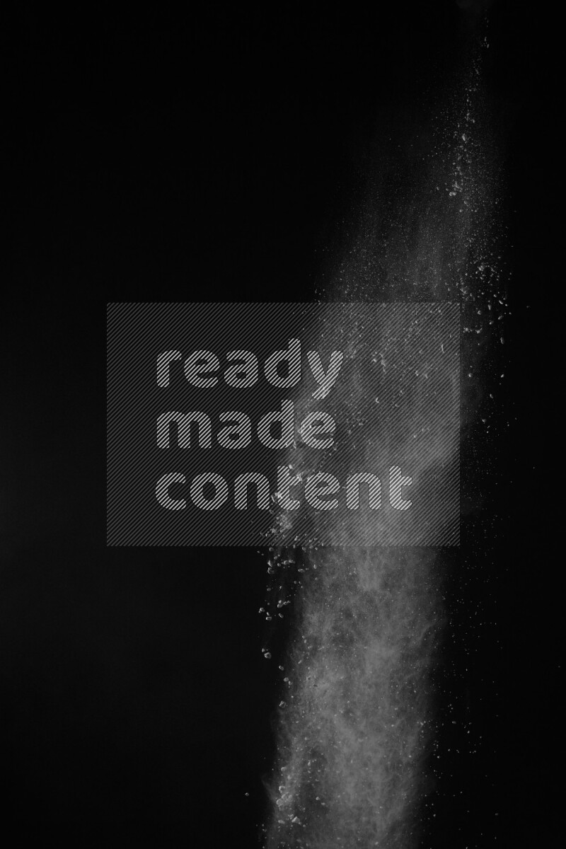 A side view of white powder explosion on black background
