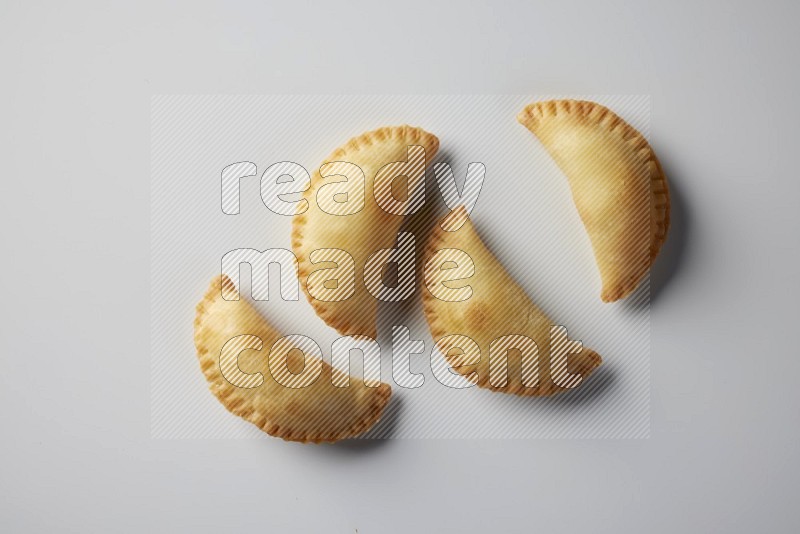 Four fried sambosa from a top angle on a white background