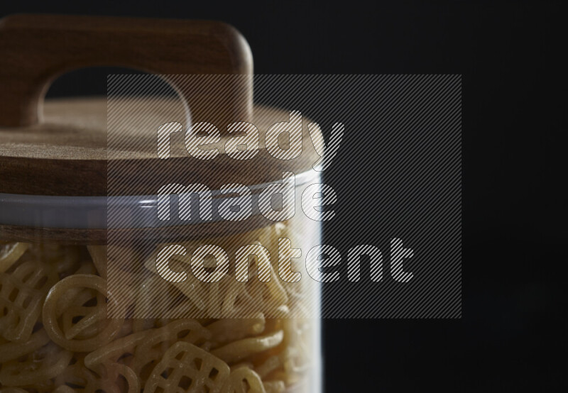 Snacks in a glass jar on black background