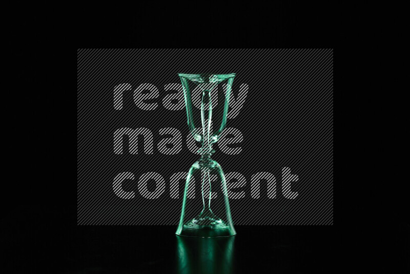 Glassware with rim light in green against black background