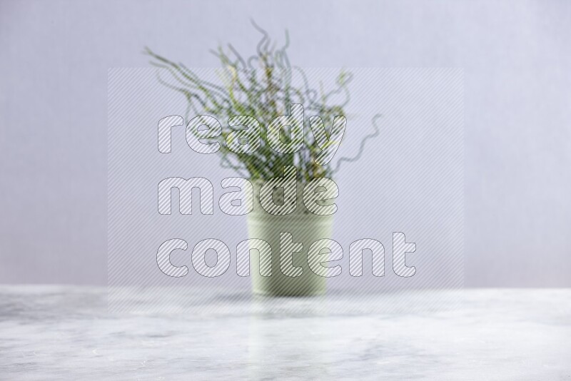 Artificial plant in green decorative pot on grey marble background