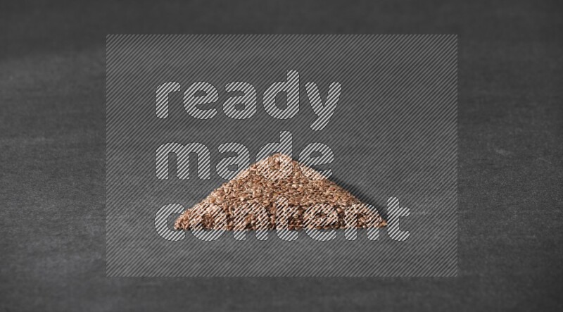 Flax Seeds in a triangle shape on a black Flooring