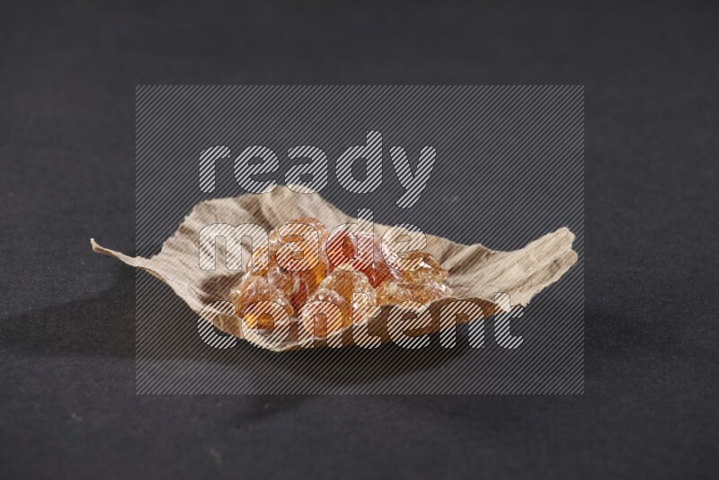 A crumpled piece of paper full of gum arabic on black flooring