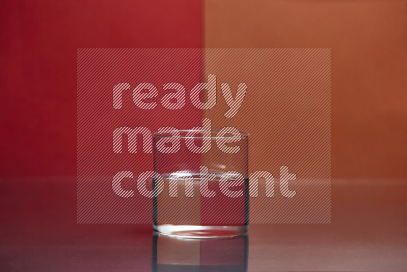 The image features a clear glassware filled with water, set against red and dark orange background