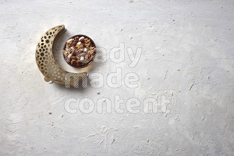 Nuts in a wooden bowl with a lantern in a light setup