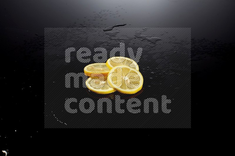 Lemon slices with water drops, and droplets on black background