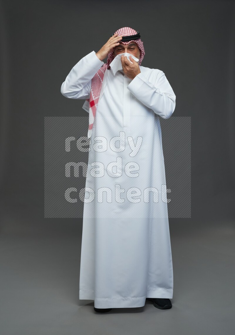 Saudi man with shomag Standing feeling sick on gray background