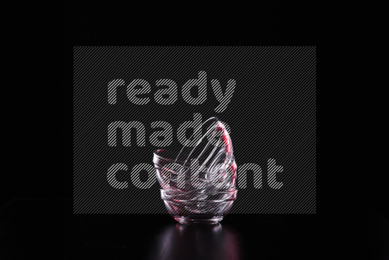 Glassware with rim light in red and white against black background