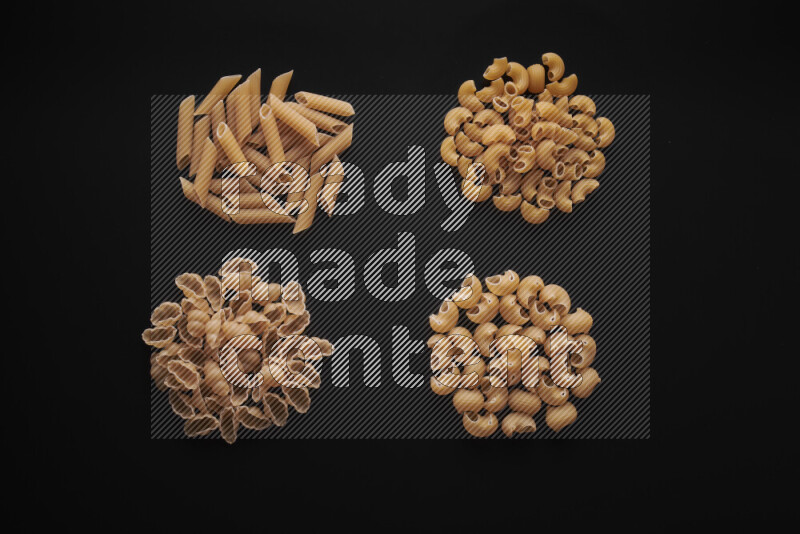 Different pasta types in bunches on black background
