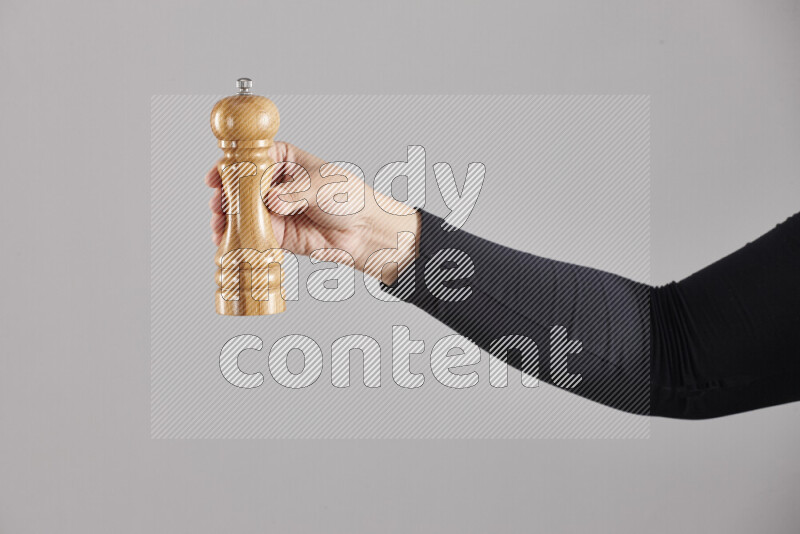 A woman in black abaya holding different wooden essentials in different positions